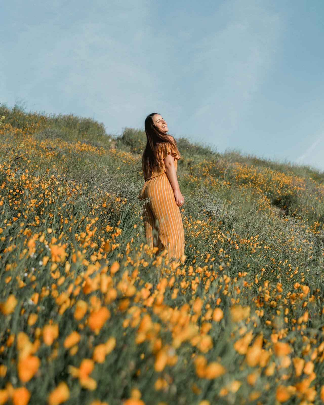 Woman Standing on Flower Field A woman standing in a field of wildflowers