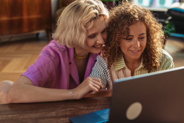 Two women looking at a laptop screen together